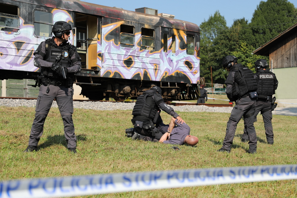 Policisti med prijetjem storilca na tleh ob vlaku