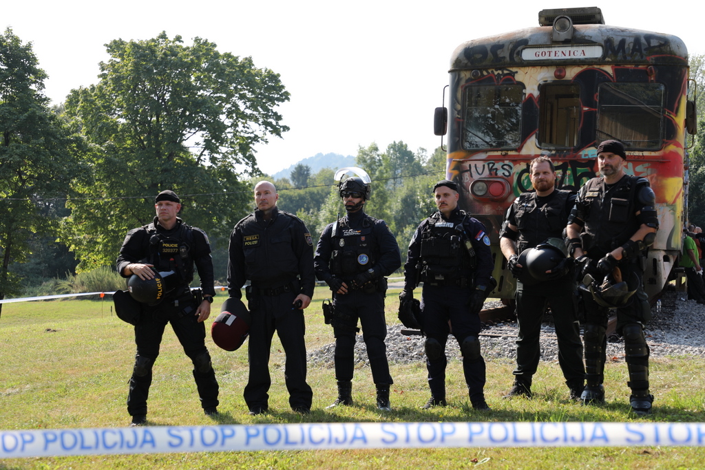 Šest policistov posebnih enot iz različnih držav - stojijo, v ozadju železniški vagon