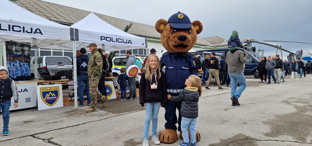 Nasmejana otroka ob policijski maskoti, policistu Leonu