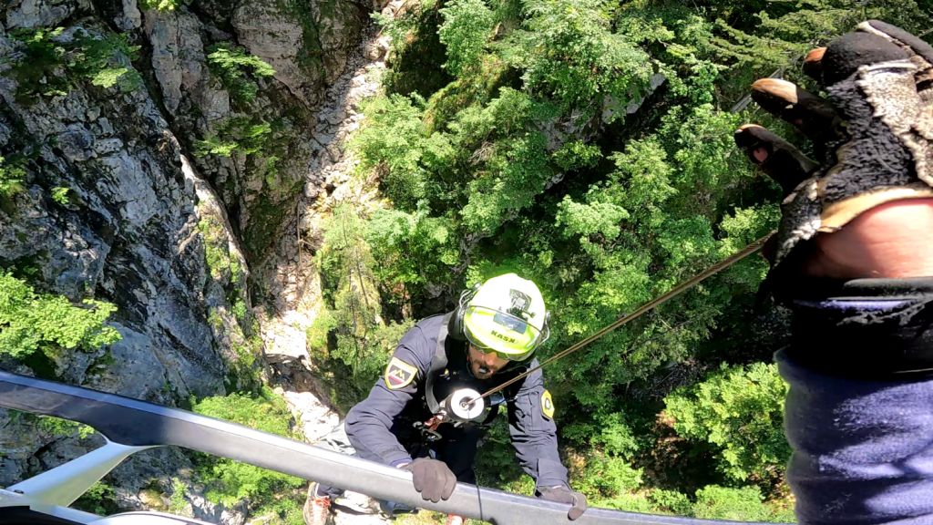 Gorski reševalec, pripadnik Letalske policijske enote, se vzpenja v policijski helikopter med letom