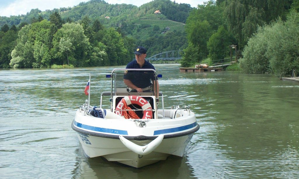 slika policista na policijskem čolnu na reki