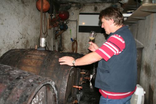 slika moškega, ki poskuša vino v vinski kleti